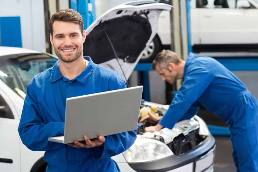 Mechanics in blue uniform inspecting car