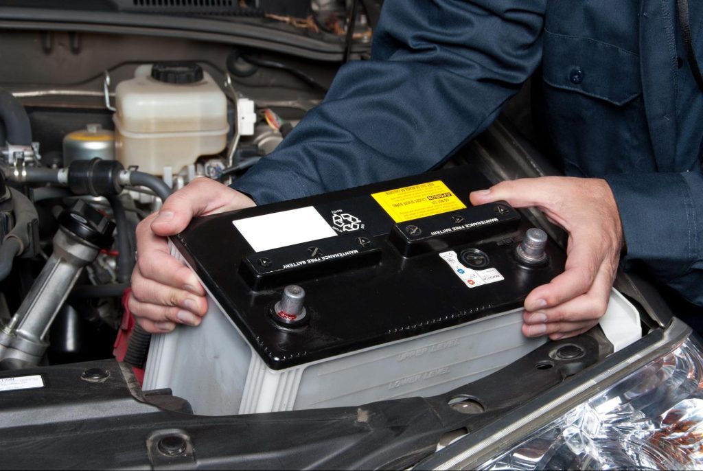 how car battery works | technician pulling out a car battery