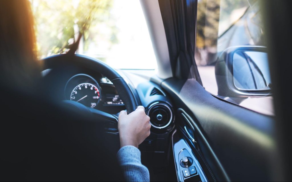 Close-up of a driver’s hands on a steering wheel illustrating potential symptoms of a bad body control module.