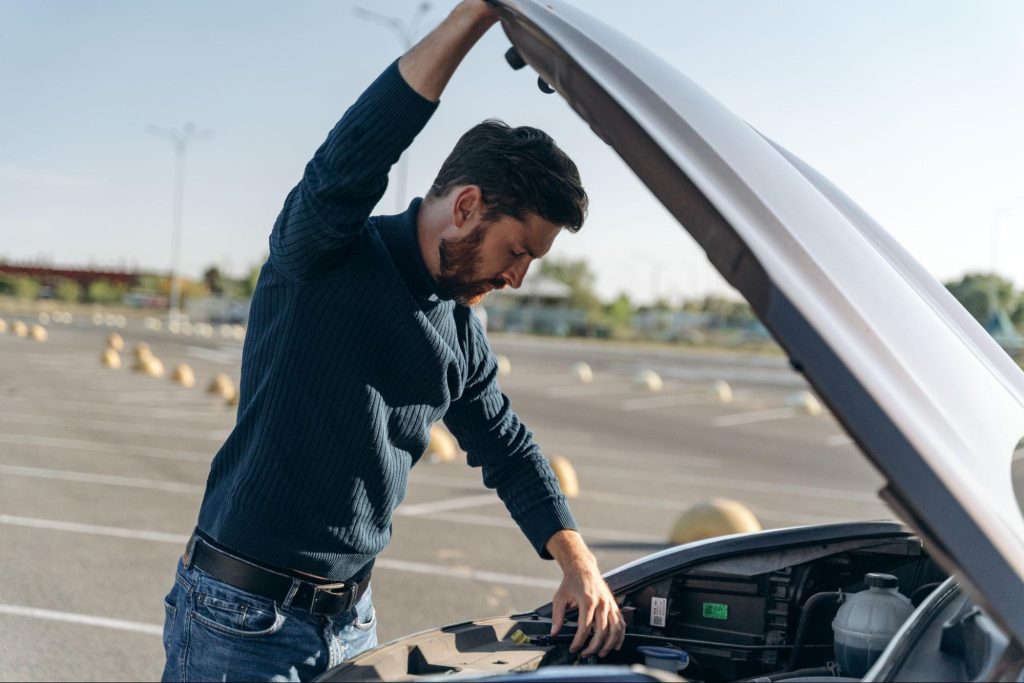 man fixing error code p0174 in parking lot