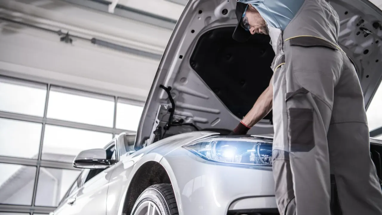 Automotive technician inspecting the engine for automotive computer reprogramming after major repair